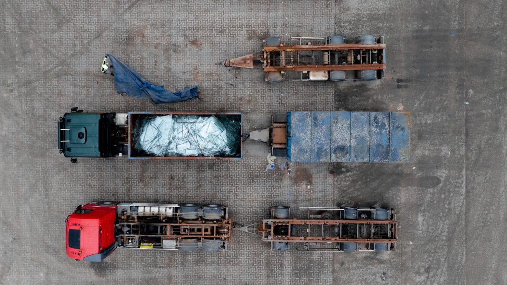 Dronefotografie van glasrecycling in Kampen met vrachtwagens en containers