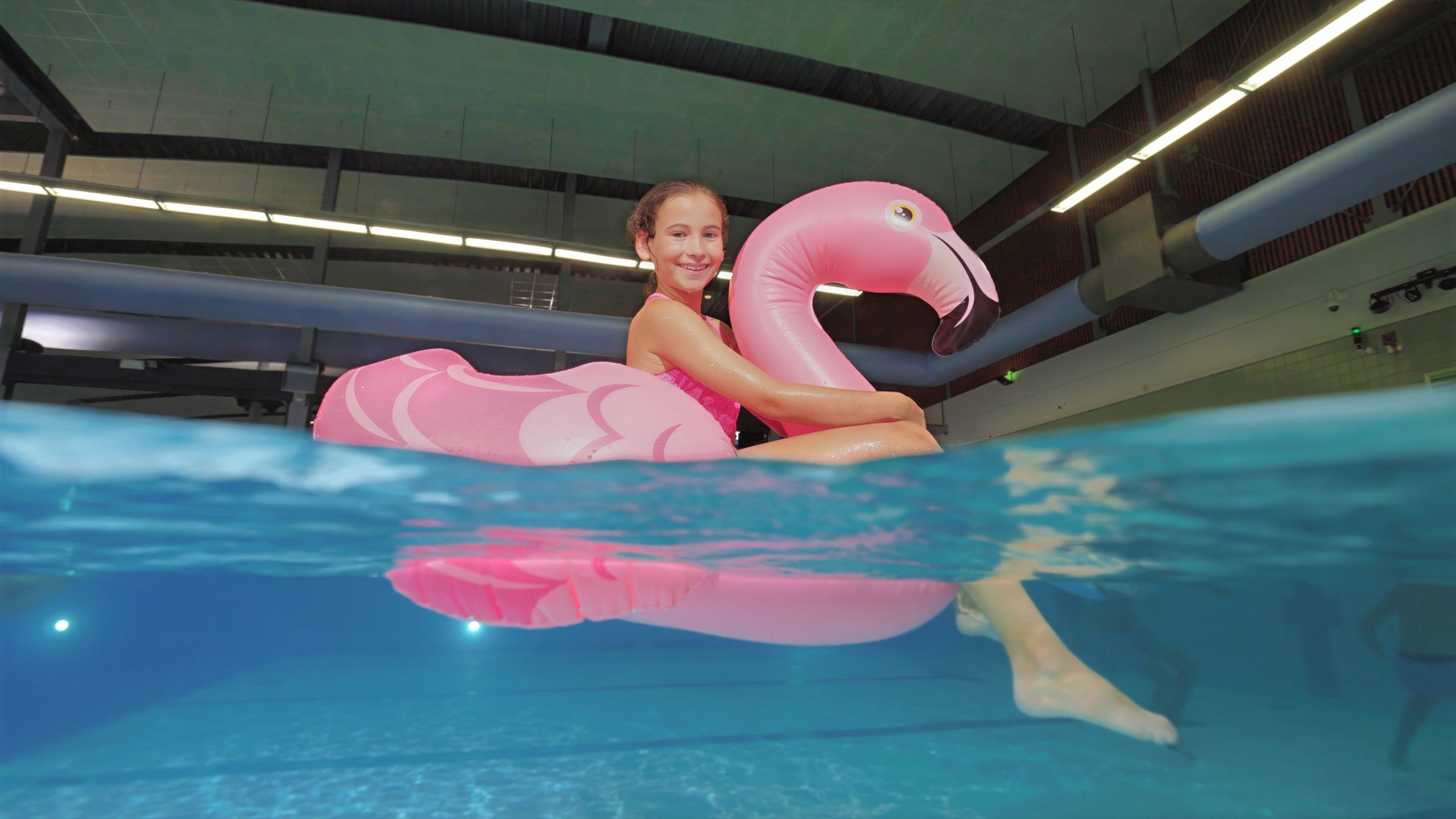 Zwembadfotografie van een kind op een roze flamingo voor Sportfondsen